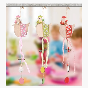 Detailed view of three colorful wooden Easter hen ornaments with floral hollow patterns