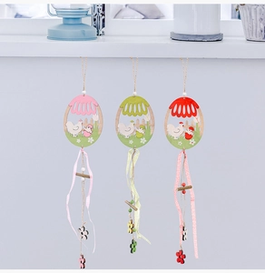 Detail of wooden Easter egg pendants with hen and chick patterns on a white background