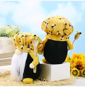 Detail of bee-themed gnome set with white beard holding wooden spoon and honey dipper