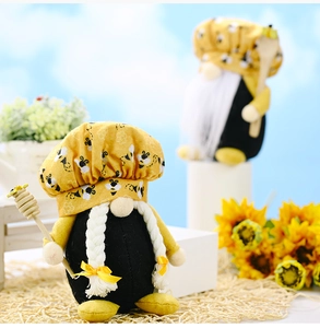 Detailed shot of handmade bee gnomes with chef hats holding honey dippers and wooden spoons