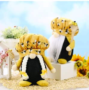 Detail of bee gnomes with chef hats holding honey dipper and wooden spoon outdoors