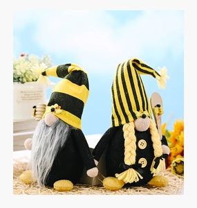 Close-up of yellow and black bee gnome plush set with striped hats and felt textures