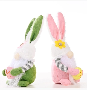 Detail of plush Easter gnomes with pink ears holding decorative eggs on white background
