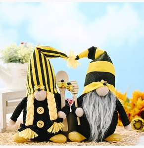 Detail of two bee gnomes featuring knitted stripes, braids, and wooden honey dippers