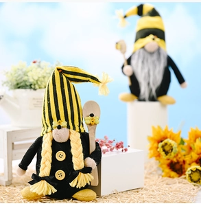 Detail of bee themed gnomes with striped hats and wooden spoons in a garden set