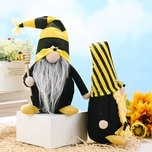 Set of two bumblebee themed gnomes with yellow stripes and sunflower decor on white block