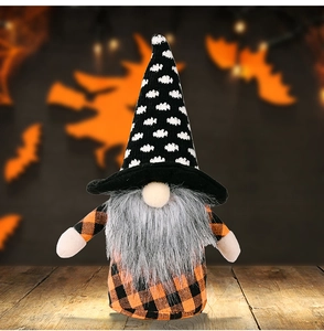 Detailed close-up of a Halloween gnome plush with orange checkered outfit on a wooden table