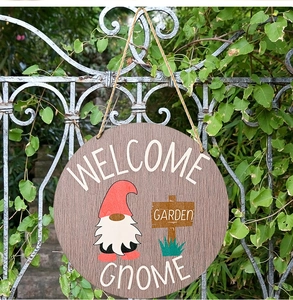 Close-up of wooden Welcome Gnome garden sign hanging on a vintage iron fence