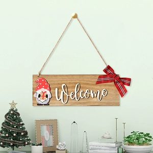 Detail of wooden Christmas Welcome sign with gnome and red plaid bow hanging on a wall