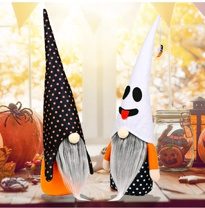 Detail of two Halloween gnomes with pointy hats among pumpkins and festive lanterns
