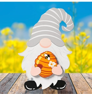 Detail of DIY wooden gnome figurine with bee hive theme on vintage wood floor