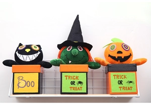 Detailed view of Halloween plush character boxes featuring a black cat, witch, and pumpkin