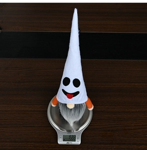 Detailed close-up of a Halloween ghost gnome plush showing actual weight on a scale
