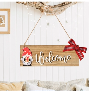 Close-up of wooden welcome sign with a Christmas gnome and red plaid bow decoration
