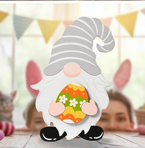 Detail of wooden Easter gnome figurine with striped hat holding a colorful painted egg