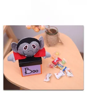 Detail view of purple Halloween candy box with a vampire plush and decorative Boo pattern