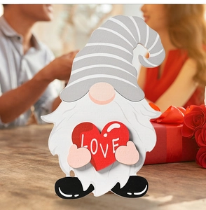 Close-up of wooden gnome decor holding a red heart with LOVE text for Valentine's Day