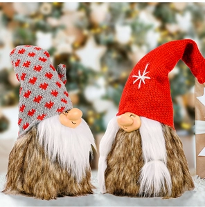 Detail of Christmas gnomes with knitted hats and white beards against festive bokeh lights