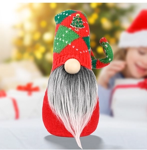 Detail of Christmas gnome with red and green knit hat and gray beard in cozy room