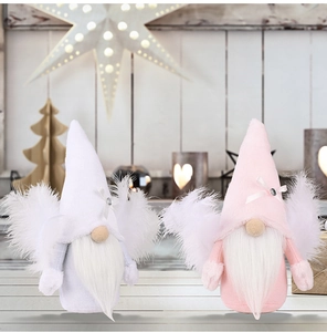 Detalle de gnomos de Navidad rosas y blancos con alas de plumas y lazos en estante de madera