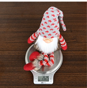 Detailed view of plush Christmas gnome weighing 262.5g on a scale for quality check