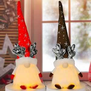 Detail of two lighted Christmas gnomes with silver antlers and warm glowing LED bases