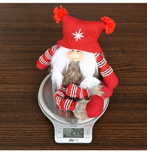 Detailed view of the Christmas gnome figurine weighing 244.0g on a digital scale