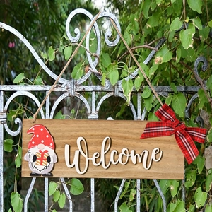 Wooden Welcome sign featuring a Christmas gnome and red plaid bow on a rustic fence