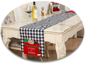 Detail of checkered Christmas table runner with Letters to Santa embroidery and gift patches