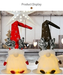 Close-up of glowing Christmas gnomes with silver antlers and warm LED lighted white beards