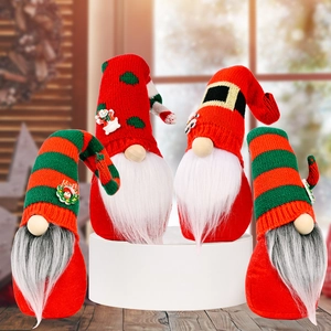 Set of four handmade Christmas gnomes with knitted hats and grey beards on white pedestals