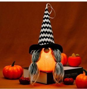 Λήψη macro ενός φωτεινού νάνου Halloween με καπέλο ζιγκ-ζαγκ και κοτσίδες σε γιορτινό σκηνικό