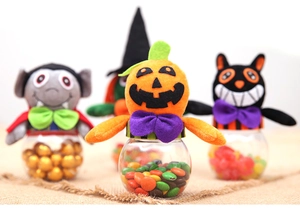 Macro view of Halloween candy jars featuring plush pumpkin and black cat heads on plastic bins