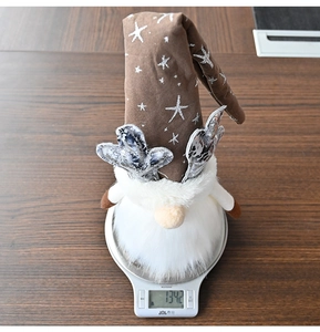 Close-up of a Rudolph gnome plush toy on a scale showing a weight of 134.2 grams