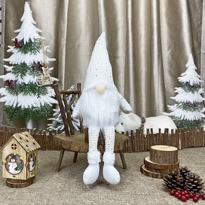 Detailed close-up of a white knitted Christmas gnome with long legs and sequin hat decoration