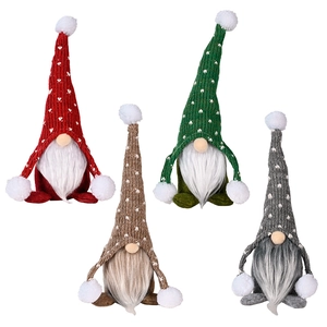 Set of four knitted Christmas gnomes with long hats and white balls in sitting posture
