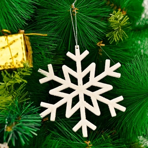 Glittery white snowflake ornament with silver string on a green Christmas tree