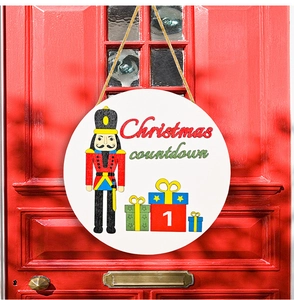 Close-up of wooden Christmas countdown calendar with nutcracker soldier on red door