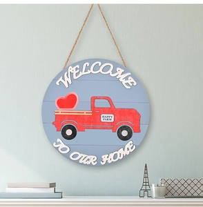 Detail of round wooden door sign with red vintage truck and Welcome To Our Home text