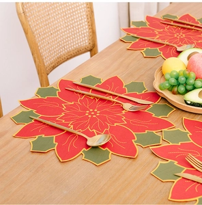 Detail of Poinsettia flower placemat with gold embroidery for Christmas table decor