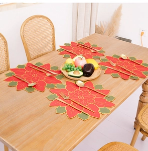 Detail of Poinsettia flower placemat with gold outline and stitching on wooden table