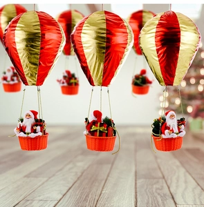 Detailed view of Santa Claus in a red and gold hot air balloon hanging ornament