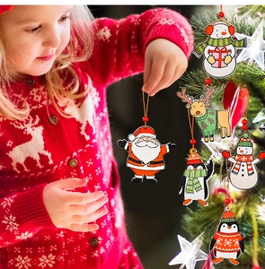 Christmas wooden pendants featuring Santa and Snowman hanging on a tree by a child