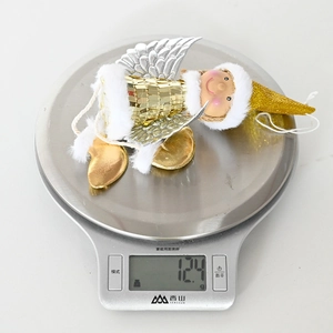 Close-up showing a 12.4g weight measurement of a Christmas sequined angel ornament