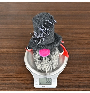 Detail shot of a Halloween gnome wizard being weighed on a digital scale at 65.8 grams