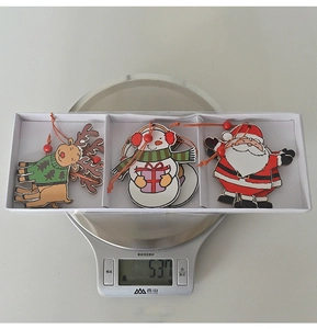 Detail view of 6-piece wooden Christmas pendants on scale showing weight of 53.7g