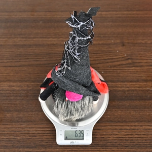 Close-up showing the weight of a Halloween vampire gnome plush on a digital scale