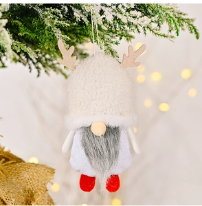 Detail of Christmas gnome ornament with sherpa hat and reindeer antlers on a tree branch