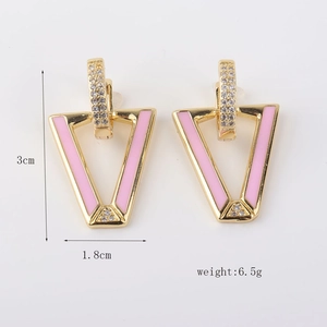 Detalle de los pendientes de esmalte rosa en forma de V con baño de oro y cristales
