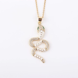 Detailopname van slangen hanger met wit emaille en groene edelsteen oogjes